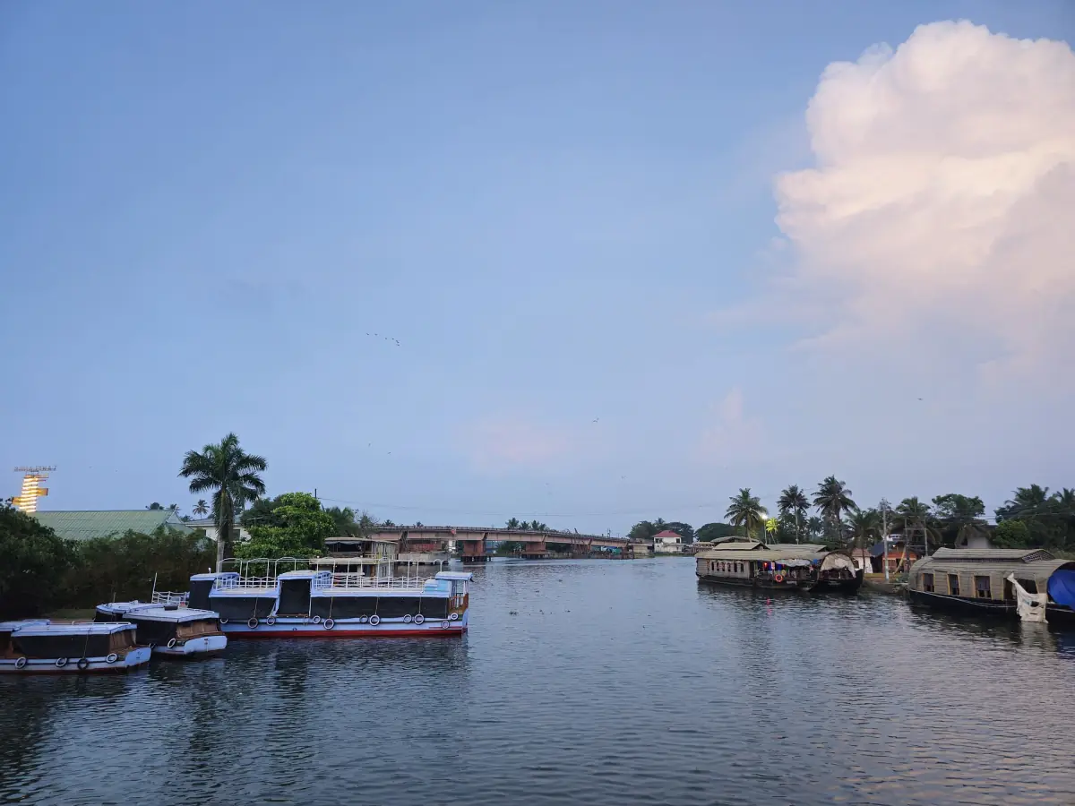 Passenger boats at a jetty on an Alappuzha waterway in evening light