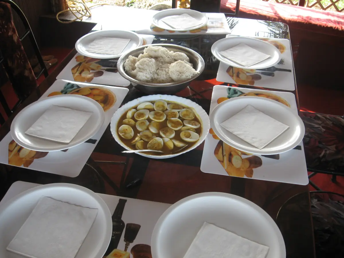 Breakfast table laid with plates and sliced fruit on a Kerala houseboat