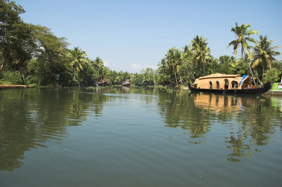 Houseboat on a calm backwater at Kumarakom with palms reflected in the water